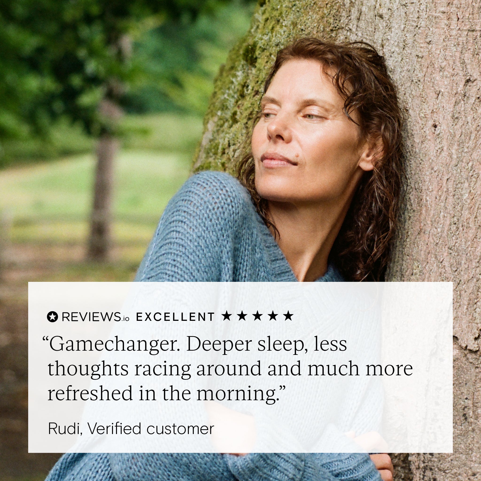 Woman leaning against a tree with a positive review text overlay