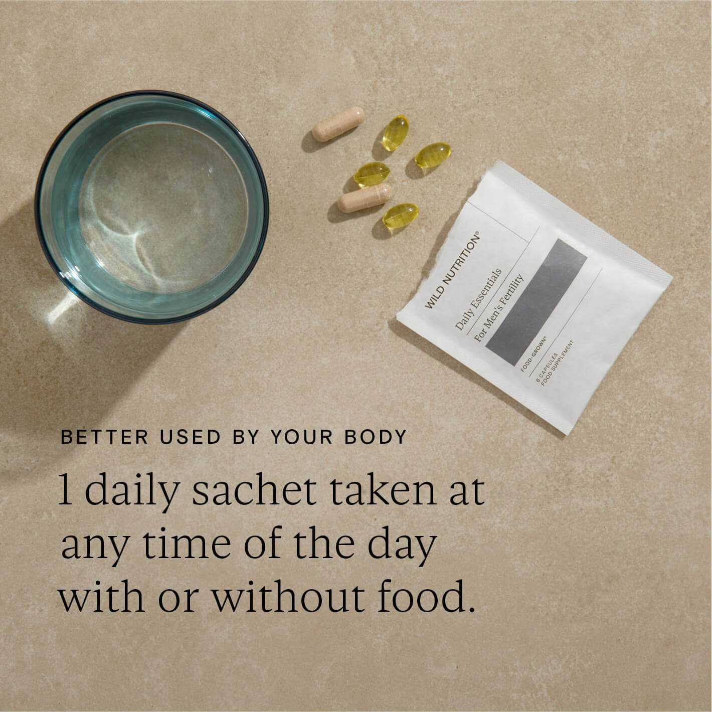 Daily sachet with omega and supplement capsules beside a glass of water, promoting men's fertility health.