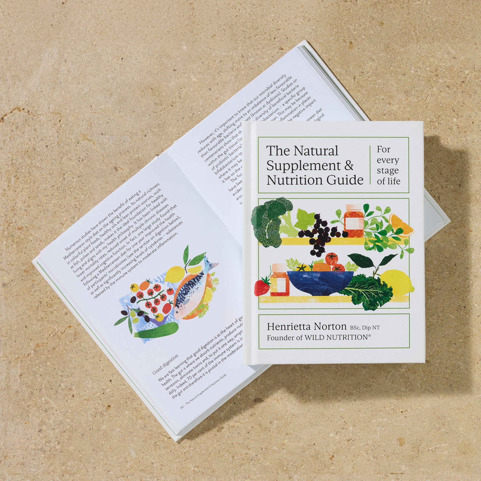 Open and closed copies of The Natural Supplement & Nutrition Guide by Henrietta Norton, showing colourful illustrations and health content on stone background