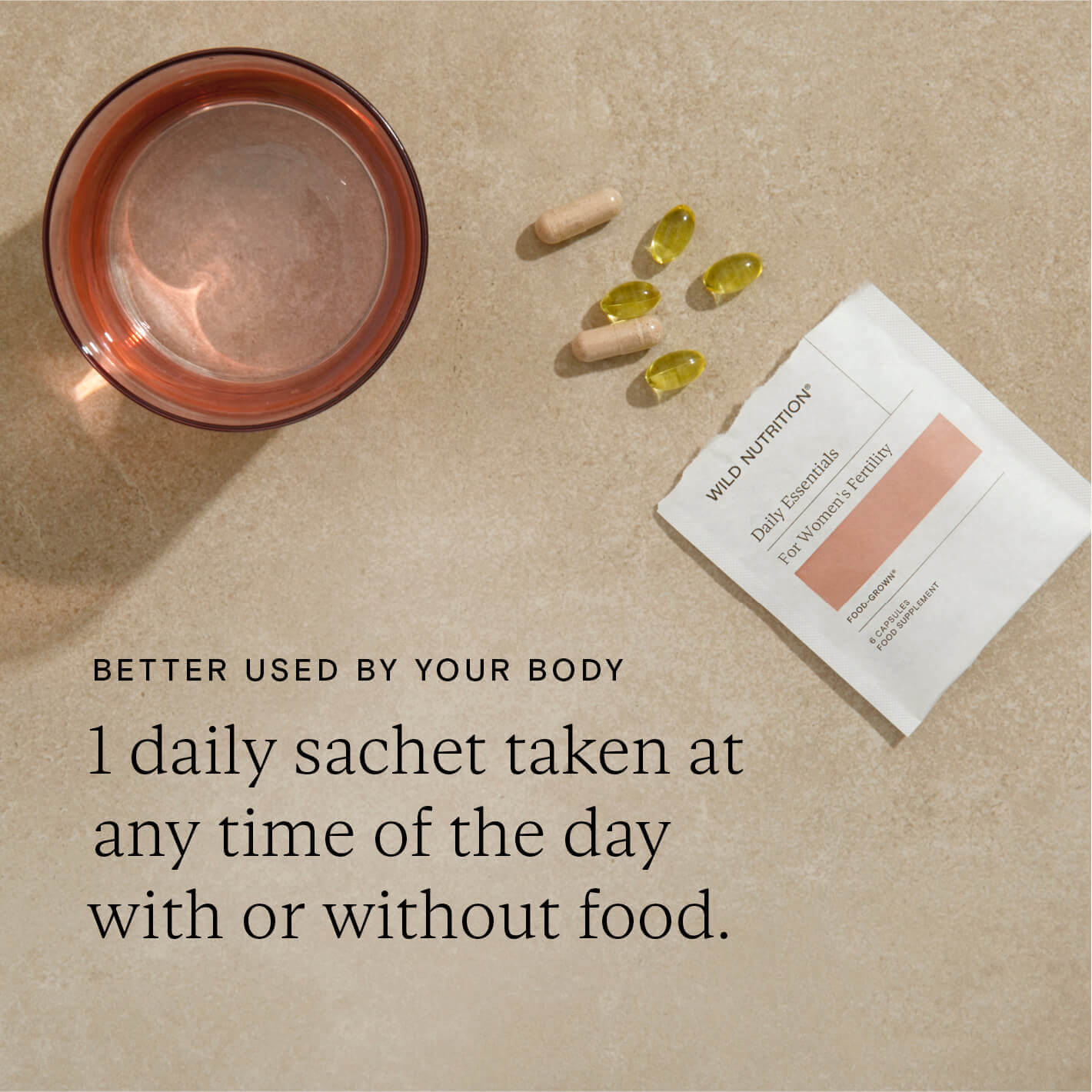 Daily Essentials Fertility supplements sachet with capsules and water, promoting nutrient support for women's fertility.