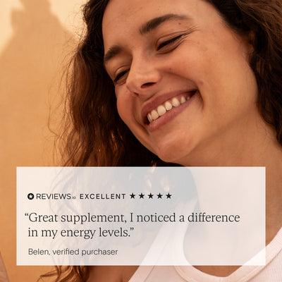 Happy woman smiling next to 5-star review for Wild Nutrition Daily Essentials for Women praising improved energy levels.