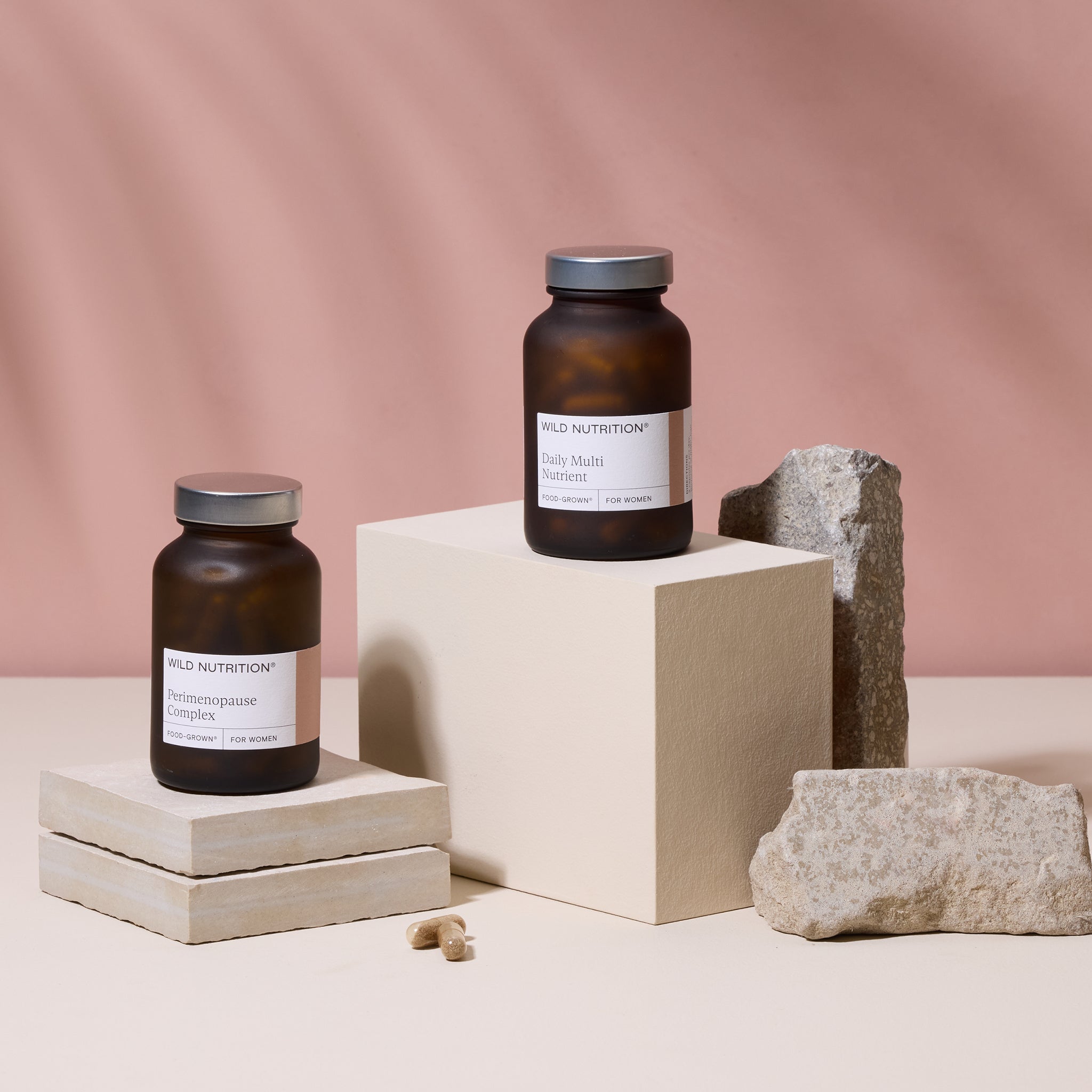 Wild Nutrition Perimenopause Complex and Daily Multi Nutrient supplements for women displayed on stone blocks with natural capsules