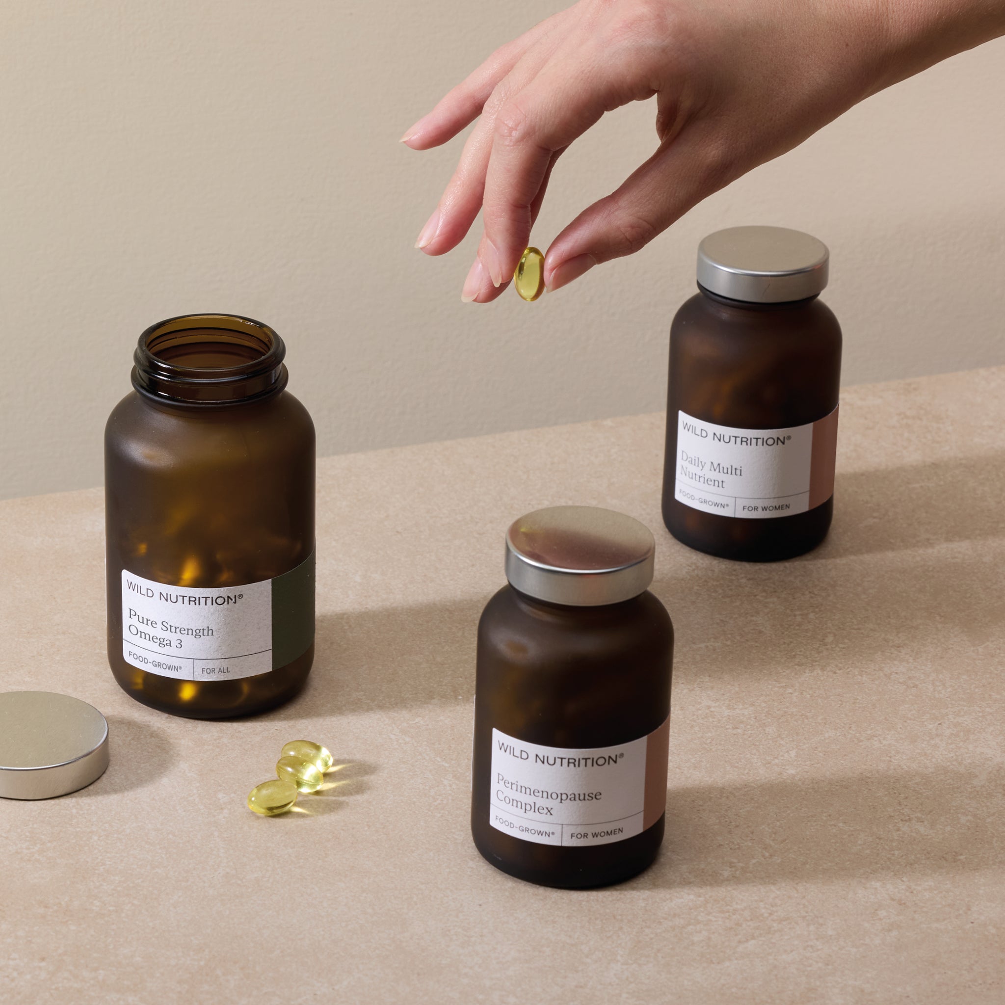 Perimenopause Support Trio including capsules from Wild Nutrition in amber jars on a neutral background.