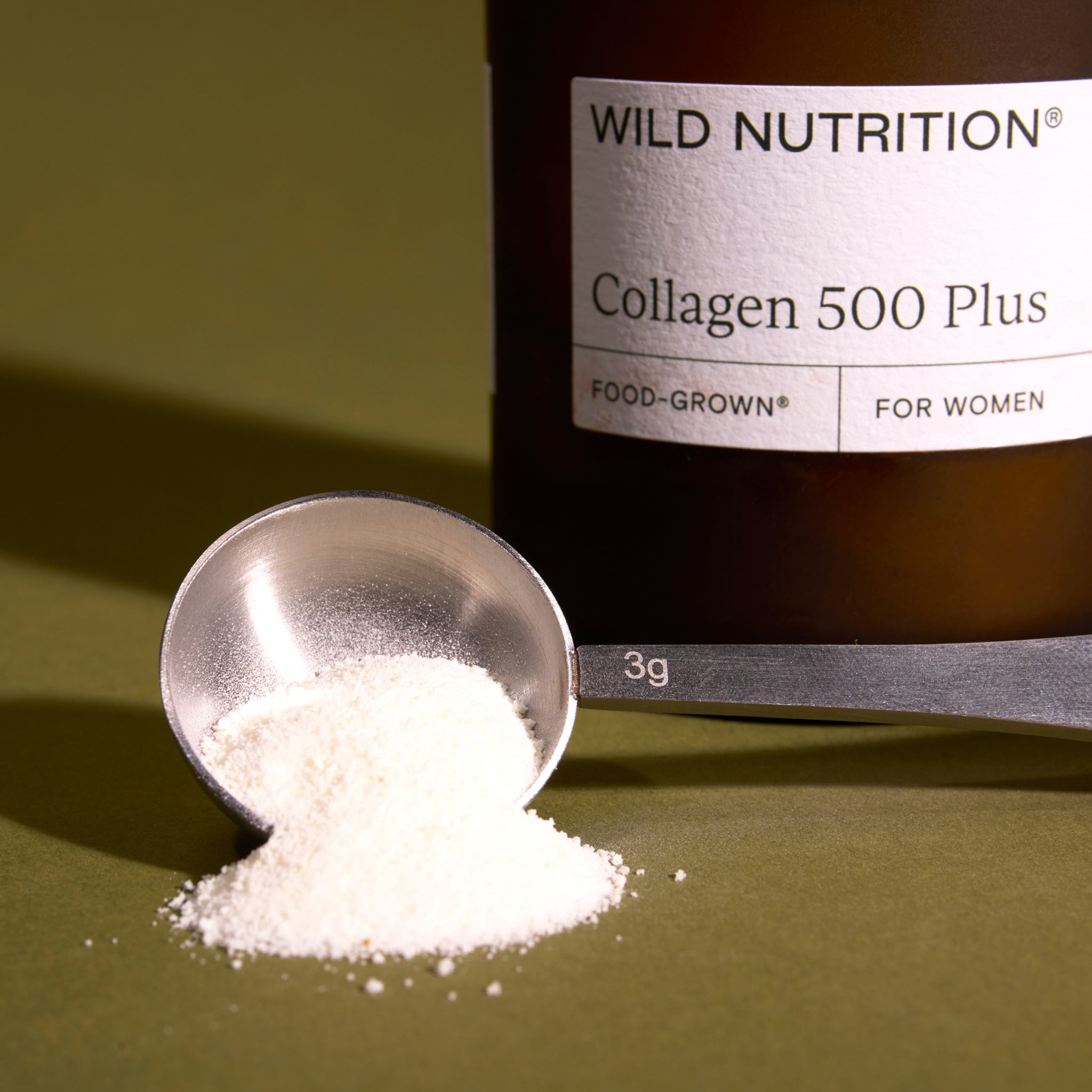 Close-up of Wild Nutrition Wellbeing Scoop powder showing fine texture and nutrient-rich blend