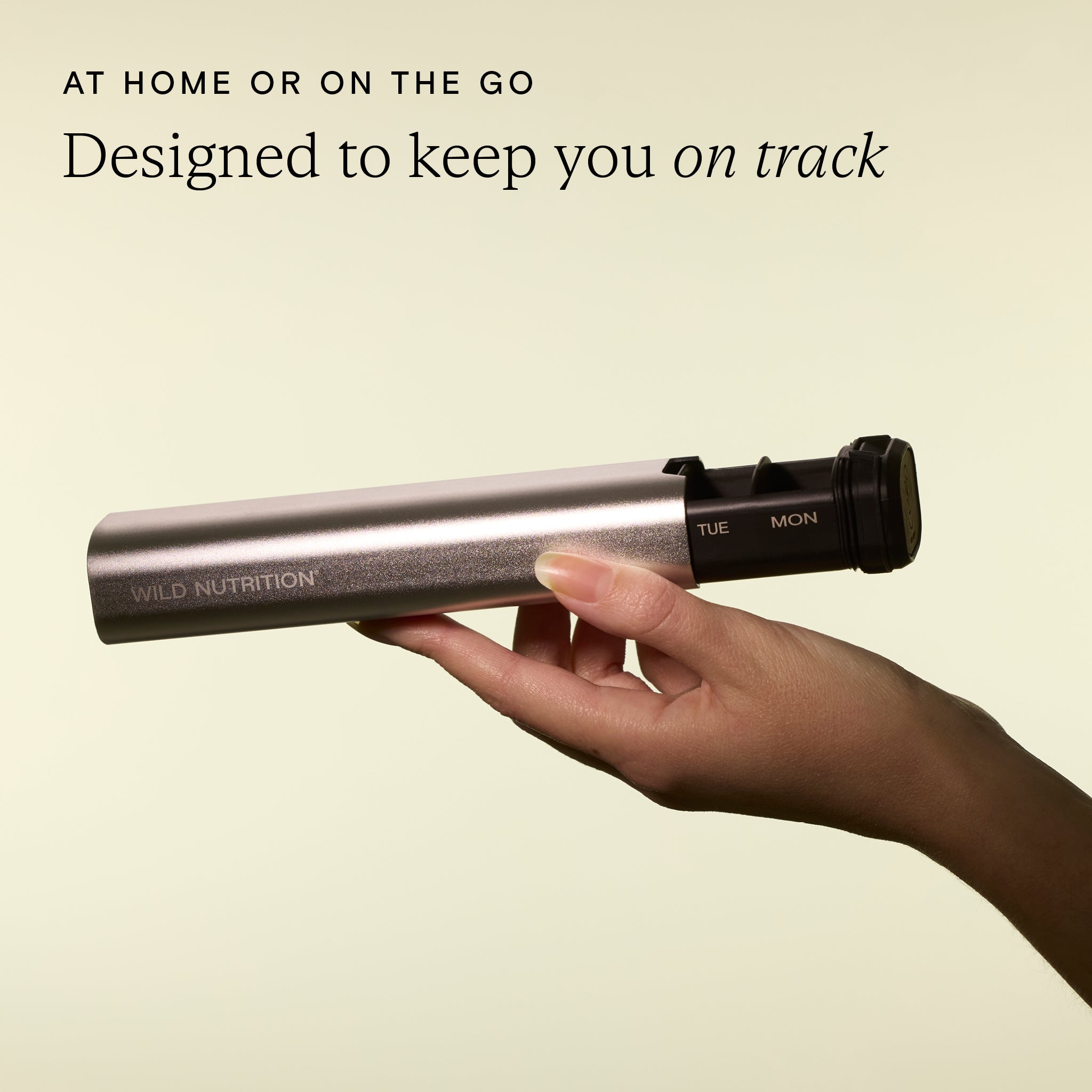 Hand holding Wild Traveller supplement organiser by Wild Nutrition with visible Monday and Tuesday compartments, designed for use on-the-go