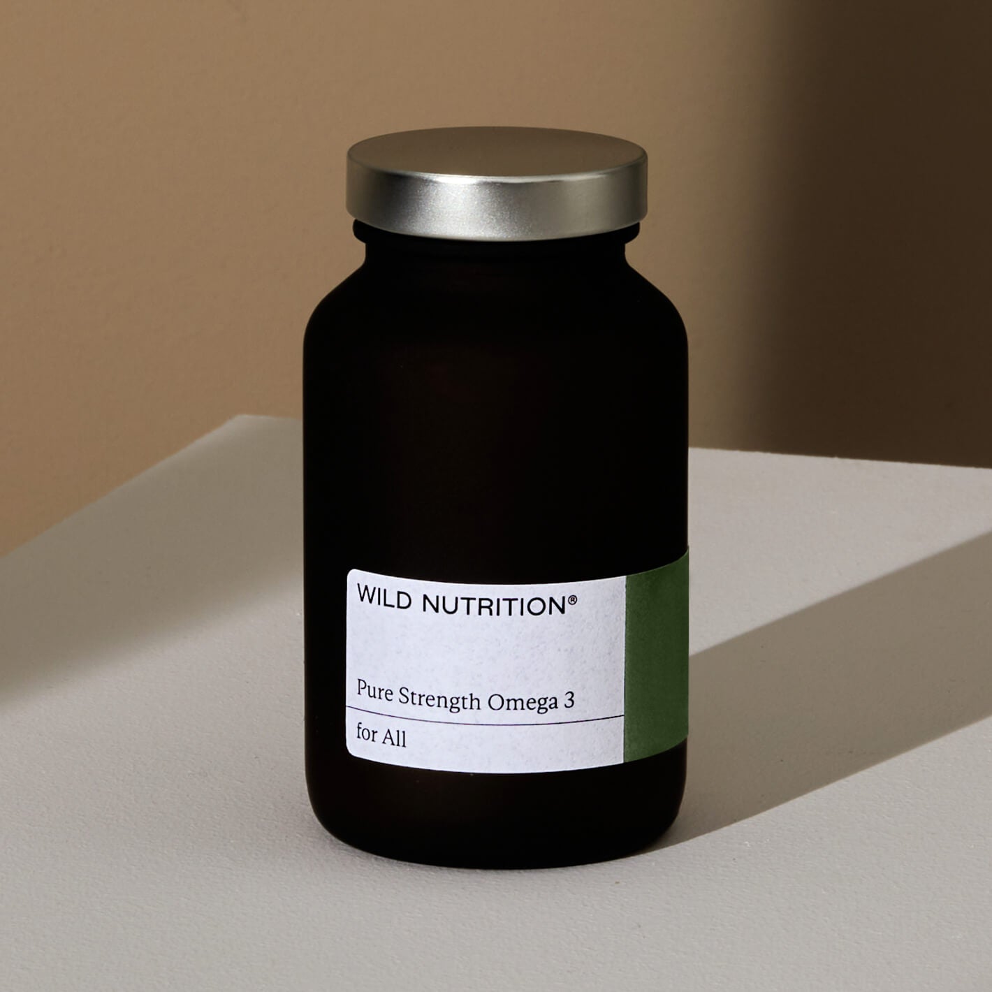 Wild Nutrition Pure Strength Omega 3 supplement bottle on a white surface, promoting health for all.