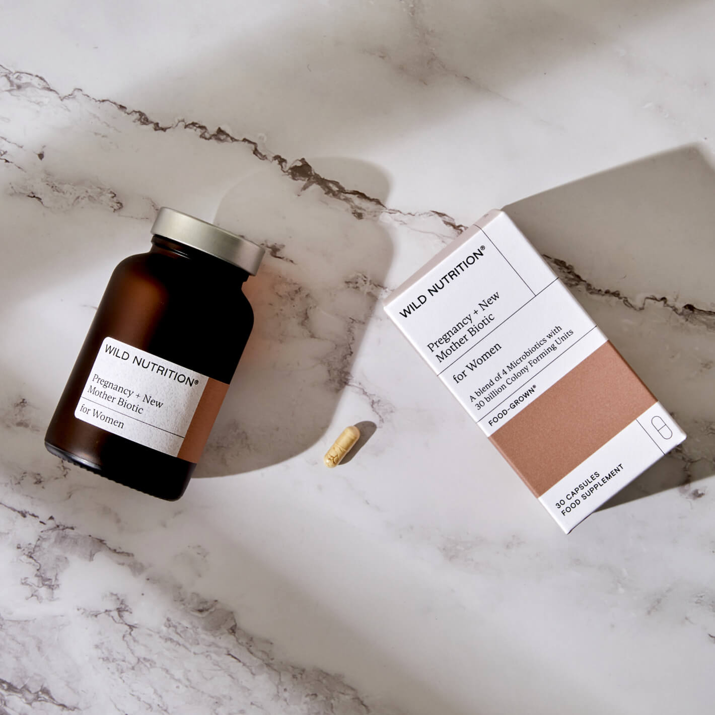 Wild Nutrition Pregnancy + New Mother Biotic supplement bottle and box on marble surface.